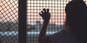 κορίτσι κρατά με τα χέρια του το συρματόπλεγμα