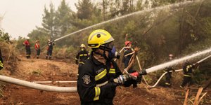 πυροσβέστες με μάνικα ρίχνουν νερό σε φωτιά στην Εύβοια