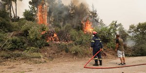 πυροσβέστης σβήνει φωτιά στην Εύβοια