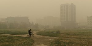 Ποδηλάτης στην πόλη Γιακούτσκ της Σιβηρίας ενώ μαίνονται οι φωτιές