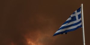 Η ελληνική σημαία με φόντο τις φωτιές στην Εύβοια