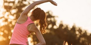γυναίκα με ροζ μπλούζα γυμνάζεται στην ύπαιθρο