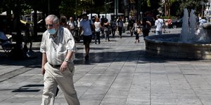 πολίτες με μάσκες περπατούν στην πλατεία Συντάγματος