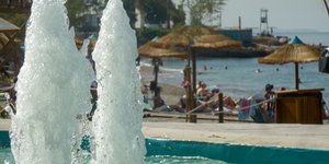 κόσμος σε παραλία λόγω ζέστης συντριβάνι