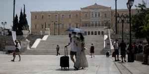 τουρίστες περπατούν στην πλατεία Συντάγματος