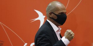 Ο Γιάνης Βαρουφάκης με το σήμα του ΜέΡΑ25 ως φόντο