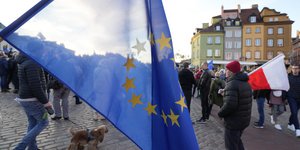 Διαδηλωτές κρατούν ευρωπαϊκές και πολωνικές σημαίες στη Βαρσοβία