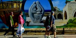 Κόσμος περπατά σε δρόμο με γκράφιτι εν μέσω της πανδημίας του κορωνοϊού