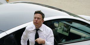 Ο Έλον Μασκ με γραβάτα βγαίνει από αυτοκίνητο
