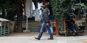 ένας άνδρας με μάσκα έξω από κατάστημα εστίασης