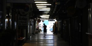 Ένας άνθρωπος περπατά σε αγορά της Μπανγκόκ της Ταϊλάνδης εν μέσω κορωνοϊού