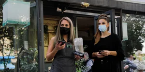 Δυο εργαζόμενες έξω από κατάστημα εστίασης