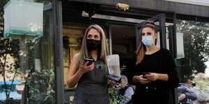 Δυο εργαζόμενες έξω από κατάστημα εστίασης