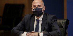 Γιώργος Καραγιάννης μάσκα σταυρωμένα χέρια μικρόφωνο