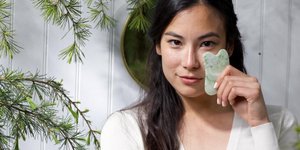 Γυναίκα κρατάει το Gua Sha