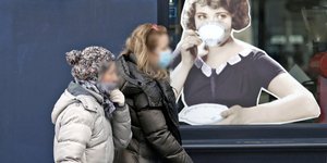 Πολίτες με μάσκες περπατούν στην Αθήνα εν μέσω πανδημίας