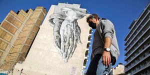 Ενας άνδρας με μάσκα περπατά στο κέντρο της αθήνας