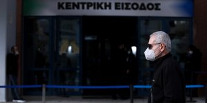άνδρας περπατά έξω από εμβολιαστικό κέντρο