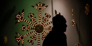 άνδρας μπροστά από βιτρίνα καταστήματος στη Βουλγαρία με στολισμούς για τα Χριστούγεννα