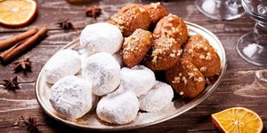 Μελομακάρονα και κουραμπιέδες σε ασημένιο πιάτο πάνω σε ξύλινο τραπέζι