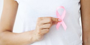 γυναίκα κρατά το σύμβολο καρκίνου του μαστού