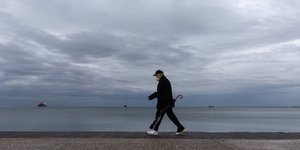 άνδρας με μάσκα περπατά σε παραλία στη Θεσσαλονίκη