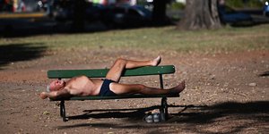 άνδρας κάνει ηλιοθεραπεία σε παγκάκι στην Αργεντινή