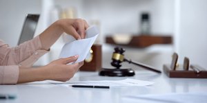 χαρτιά αποζημίωσης δίπλα σε σφυρί