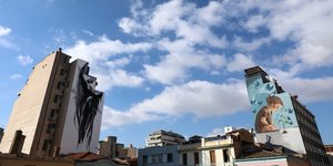 Σύννεφα στον Αττικό ουρανό και πολυκατοικίες με γκράφιτι