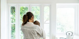 γυναίκα πλάτη κρατά αγκαλιά ένα μωρό