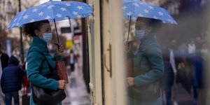 Γυναίκα με μάσκα χαζεύει βιτρίνα στην Ισπανία