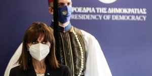 Η Κατερίνα Σακελλαροπούλου στέκεται μπροστά από εύζωνα της Προεδρικής Φρουράς