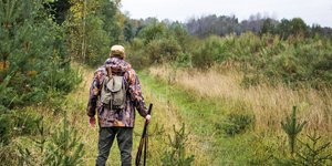 Κυνηγός με καραμπίνα σε δάσος