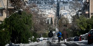 Κόσμος περπατά στη χιονισμένη Αθήνα