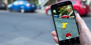 ανδρικό χέρι κρατά κινητό και παίζει Pokemon Go