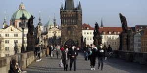 Πολίτες, κάποιοι με μάσκες, στη γέφυρα Καρόλου στην Πράγα