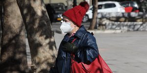 γυναίκα με μάσκα και κόκκινο σκουφί στην Πλατεία Συντάγματος