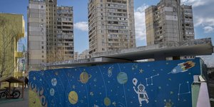 Ένας άνδρας περπατά δίπλα σε έναν βαμμένο τοίχο σε ένα σχολικό προαύλιο, στο Κίεβο