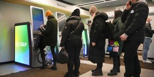 Κόσμος περιμένει να βγάλει χρήματα σε ρωσική τράπεζα στη Μόσχα