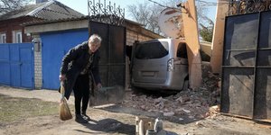 Μια γυναίκα καθαρίζει τα συντρίμμια, από τον πύραυλο που έπεσε κοντά στο σπίτι της, στο Χάρκοβο