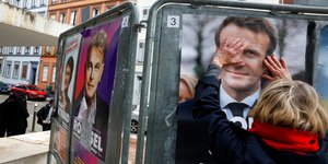 Γυναίκα αγγίζει αφίσα του Εμανουέλ Μακρόν στο Στρασβούργο στον α΄γύρο των γαλλικών προεδρικών εκλογών