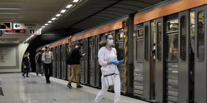 μια γυναίκα με μάσκα μπαίνει σε βαγόνι του μετρό