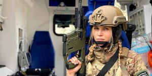 Κira Nechay με στρατιωτικά και όπλο στο χέρι 