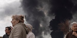 Άνθρωποι στην Οδησσό κοιτούν τους καπνούς ύστερα από βομβαρδισμούς/ Πηγή: AP/ Petros Giannakouris
