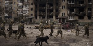 Ουκρανοί στρατιώτες περπατούν δίπλα σε κατεστραμμένα κτίρια κατοικιών στο Ιρπίν, στα περίχωρα του Κιέβου