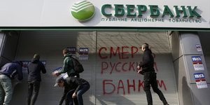 Διαδηλωτές τοποθετούν αφίσες που γράφουν: «Προσοχή! Αυτή είναι μια τράπεζα μιας επιτιθέμενης χώρας. Θα κλείσει. Αποσύρετε επειγόντως τα χρήματά σας», στο Κίεβο το 2017