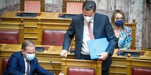 Ο Θεόδωρος Σκυλακάκης στη Βουλή, με τον Κώστα Καραμανλή να του ετοιμάζει την καρέκλα