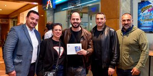 Ο νικητής της κλήρωσης με τον ιδιοκτήτη του καταστήματος ΟΠΑΠ και την ομάδα του ΟΠΑΠ