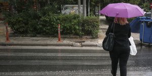 Μια γυναίκα με ομπρέλα στη βροχή