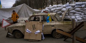 Ένας άνδρας της πολιτοφυλακής στέκεται σε ένα σημείο ελέγχου που έχει στηθεί σε έναν δρόμο που κατευθύνεται προς την πόλη του Κιέβου,